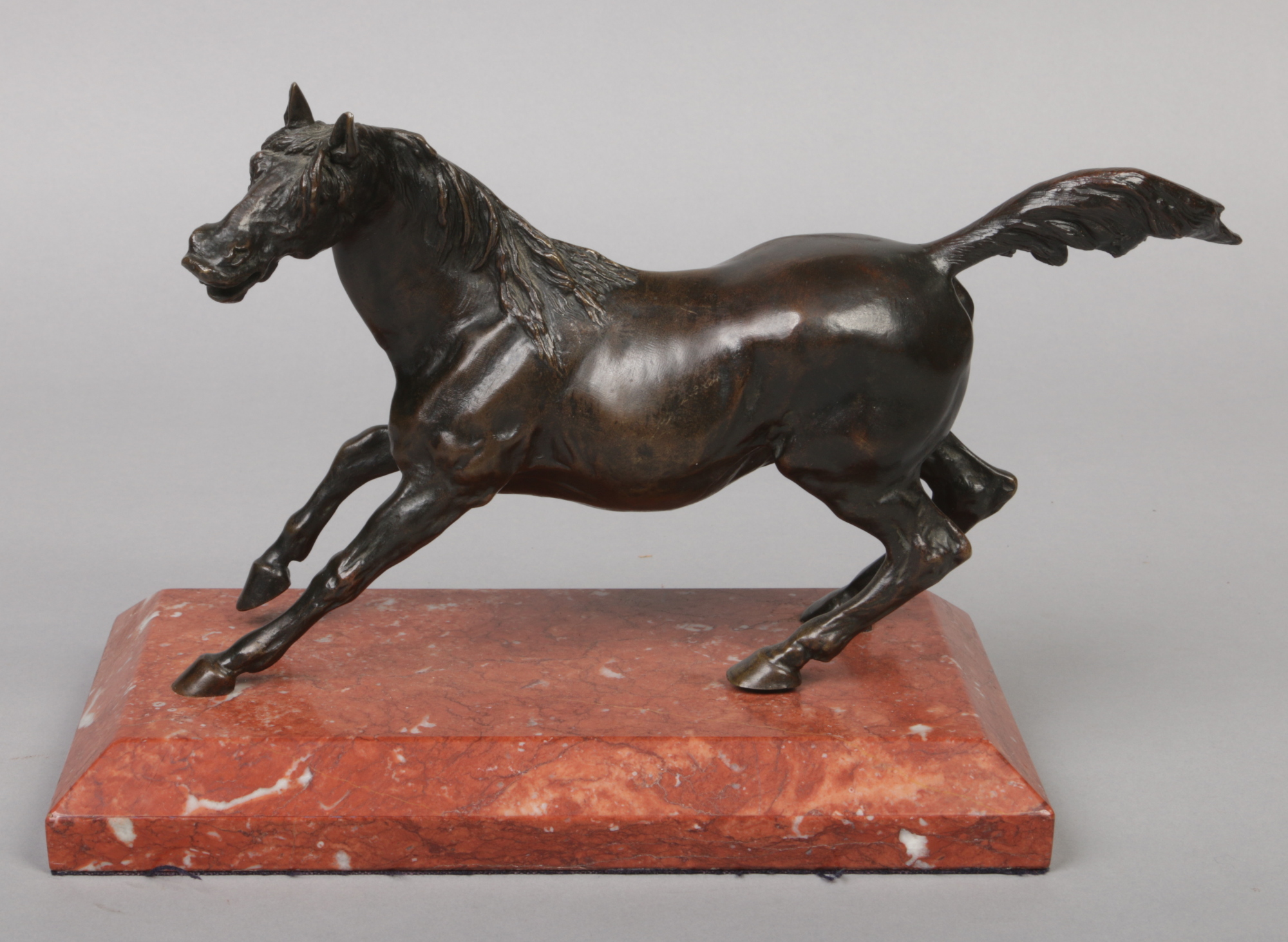 A 19th century Continental patinated bronze sculpture of a stallion raised on a bevelled rectangular