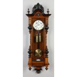 A 19th century walnut twin weight Vienna wall clock. With ebonized mouldings and enamel dial with