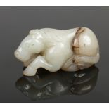 A Chinese carved pale celadon jade recumbent horse with dark brown suffusions, 7.75cm.Condition