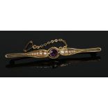 A 15 carat gold bar brooch set with an amethyst and seed peals on a milgrain openwork setting,