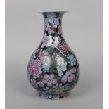 A Chinese famille noir pear shaped vase. Decorated in coloured enamels with mixed flowers and with