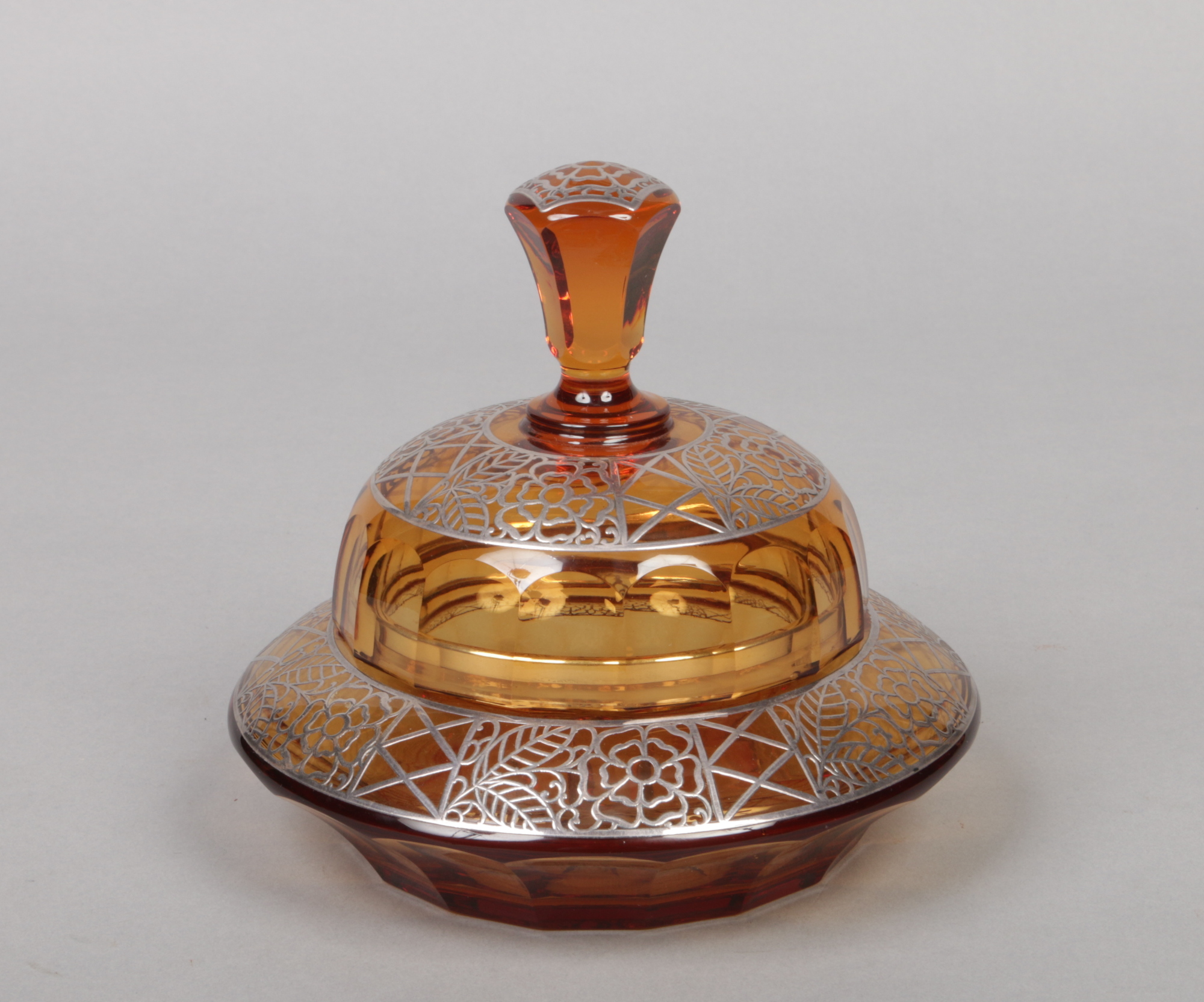 An Art Deco cut amber glass bon bon dish and cover with silver overlay decoration and faceted