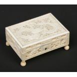 A 19th century Cantonese carved and pierced ivory box with hinged cover and raised on turned feet,