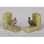 A pair of onyx and cold painted bronze bookends. Surmounted one with a partidge and one with a