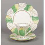 A Rockingham primrose leaf moulded coffee cup with crossed-twig handle, a saucer and a side plate.