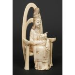 A Japanese Meiji period carved ivory okimono, Formed as a maiden seated upon a throne and with a