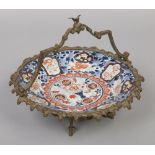 A Japanese Edo period Imari dish decorated with flowers and butterflies. With later gilt bronze