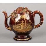 A Brameld brown glazed earthenware Cadogan hot water jug. Painted and gilded to one side with a