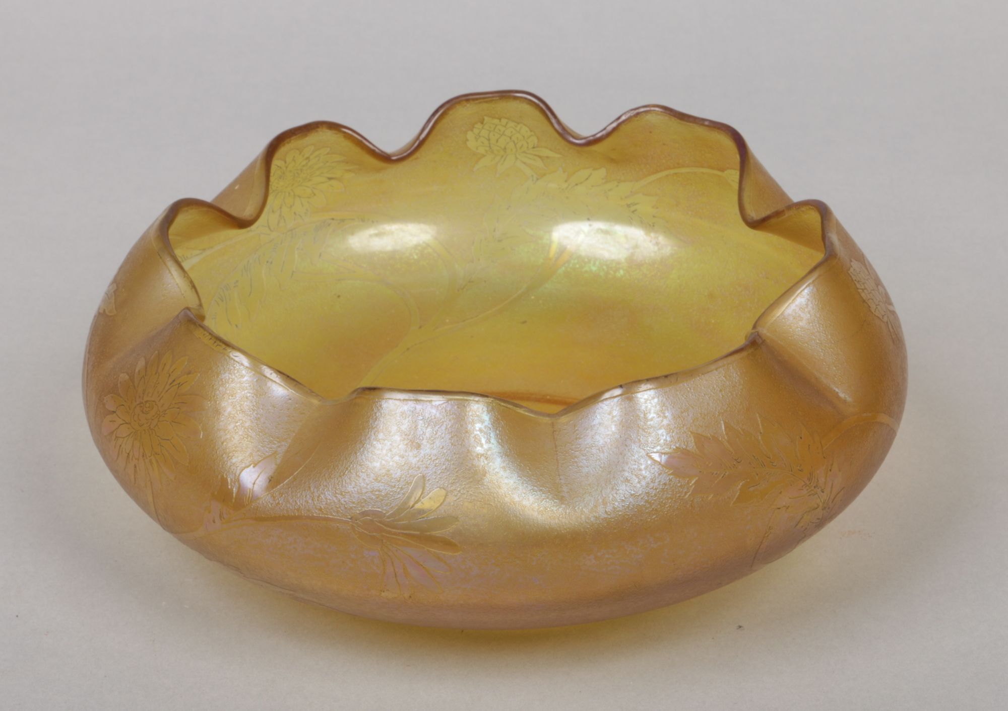 A Tiffany style glass bowl etched with stylized flowers and with frilled rim, 22cm wide. Condition