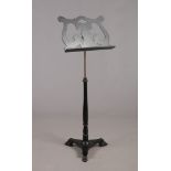 An ebonized Salvi rise and fall music stand. Raised over a triform base terminating on paw feet,