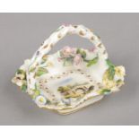 A small Rockingham flower encrusted basket with rustic arched handle. Painted with a romantic