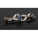An Edwardian yellow metal bar brooch, with a central sapphire and leaf formed diamond studded