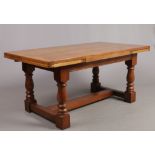 An oak plank top drawer leaf refectory dining table with pegged construction and raised on a H-