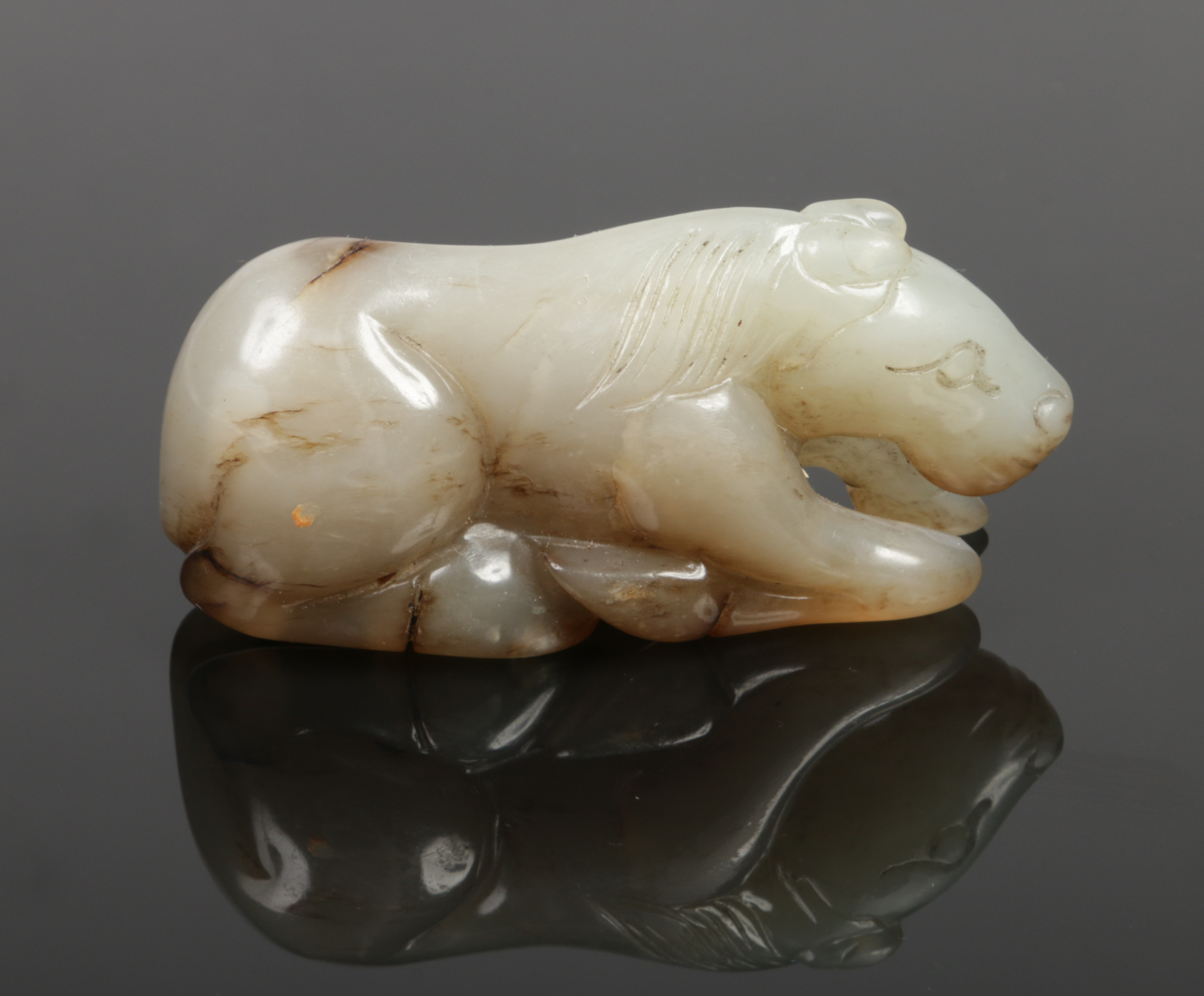 A Chinese carved pale celadon jade recumbent horse with dark brown suffusions, 7.75cm.Condition - Image 4 of 4