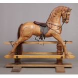 A Victorian style carved hardwood child's rocking horse with leather saddle and bridle, 105cm high.