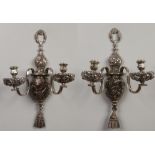 A pair of silver plated twin branch wall lights. Cast in relief with scrolling foliage and flowers