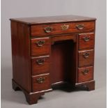 A George II mahogany kneehole writing desk raised on bracket supports, 74cm wide, 75cm high, 46cm
