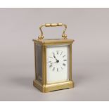 A brass cased carriage clock with Swiss movement with white enamel dial, Roman numeral baton