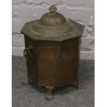 A hammered copper plate octagonall shaped coal / log box, raised on spade feet.