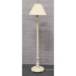 A white painted standard lamp with reeded and turned column.