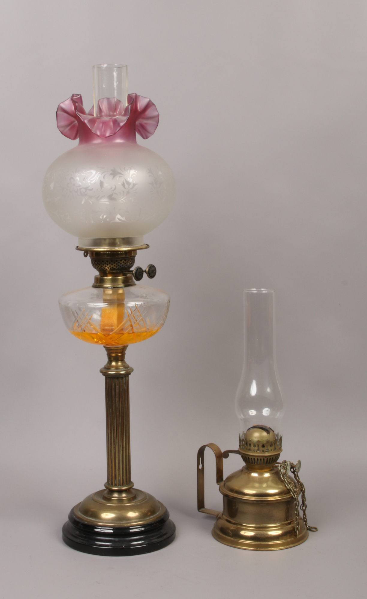 A late 19th / early 20th century brass based oil lamp with etched and ruby glass shade, along with a