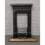 A Victorian cast iron bedroom fire place with shelf and grate, recently blacked, along with a copper