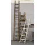 A pair of wooden step ladders, along with a aluminium step ladder and a double wooden ladder.