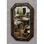 A carved oak bevel edge wall mirror with canted corners.