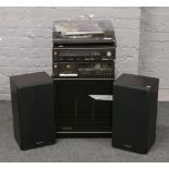 A Technics music system and speakers in record storage cabinet.