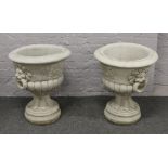 A large pair of cast pedestal garden urns with lion mask handles.