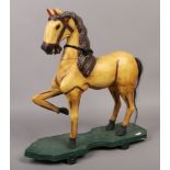 An antique style painted wooden horse on wheeled shaped plinth.