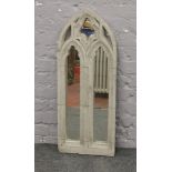 A stone effect Gothic style arch top garden mirror.