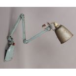 A vintage industrial engineers wall mounting task lamp on five way hinged arm.