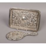 A silver tray with repousse decoration, assayed Birmingham 1900, along with a similar silver hand