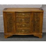 A carved hardwood Chinese style sideboard decorated with figures in landscapes.