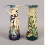 Two Moorcroft jugs, one decorated with flowers, berries and insects, along with a trial example.