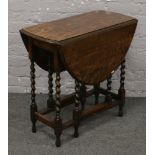 A carved oak barleytwist occasional drop leaf table.