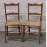 A pair of George V bedroom chairs with canework seats.