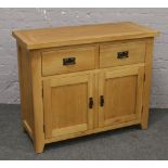 A modern oak sideboard with two drawer over cupboard base.