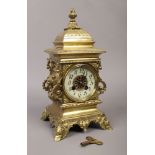 A French brass 8 day bracket clock with twin lion mask handles, enamelled chapter ring, having a