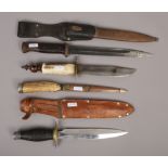 A German World War II bayonet in scabbard along with three other knives to include antler handled