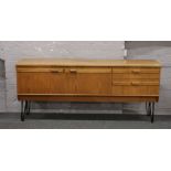 A 1960s teak sideboard raised on painted steel legs by Portwood Furniture Stockport, 184cm x 46cm