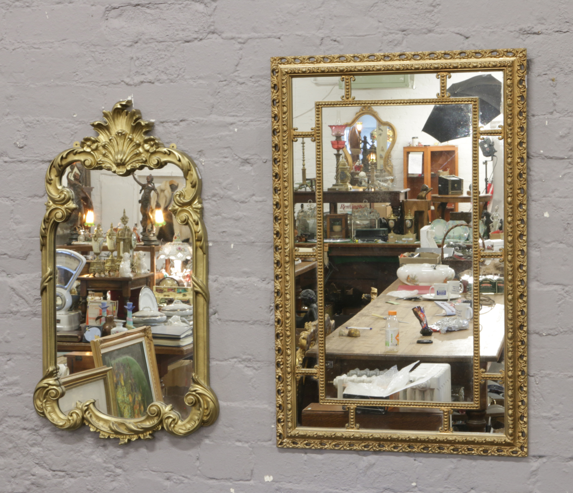 Two gilt framed ornate wall mirrors.