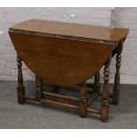 A carved and turned oak drop leaf table.