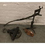 A vintage iron cart jack, along with two pulleys.