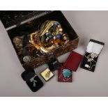A tin of costume jewellery to include pendants on chains, wristwatches etc.