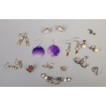 Twelve pairs of silver earrings including amethyst and pearl examples.
