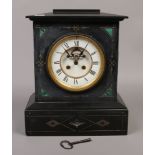 A Victorian slate and malachite mantle clock with visible anchor escapement, white enamel and