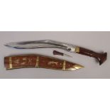 A Kukri knife in brass mounted wooden sheath decorated with animals.