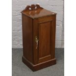 A Victorian carved and panelled mahogany pot cupboard.